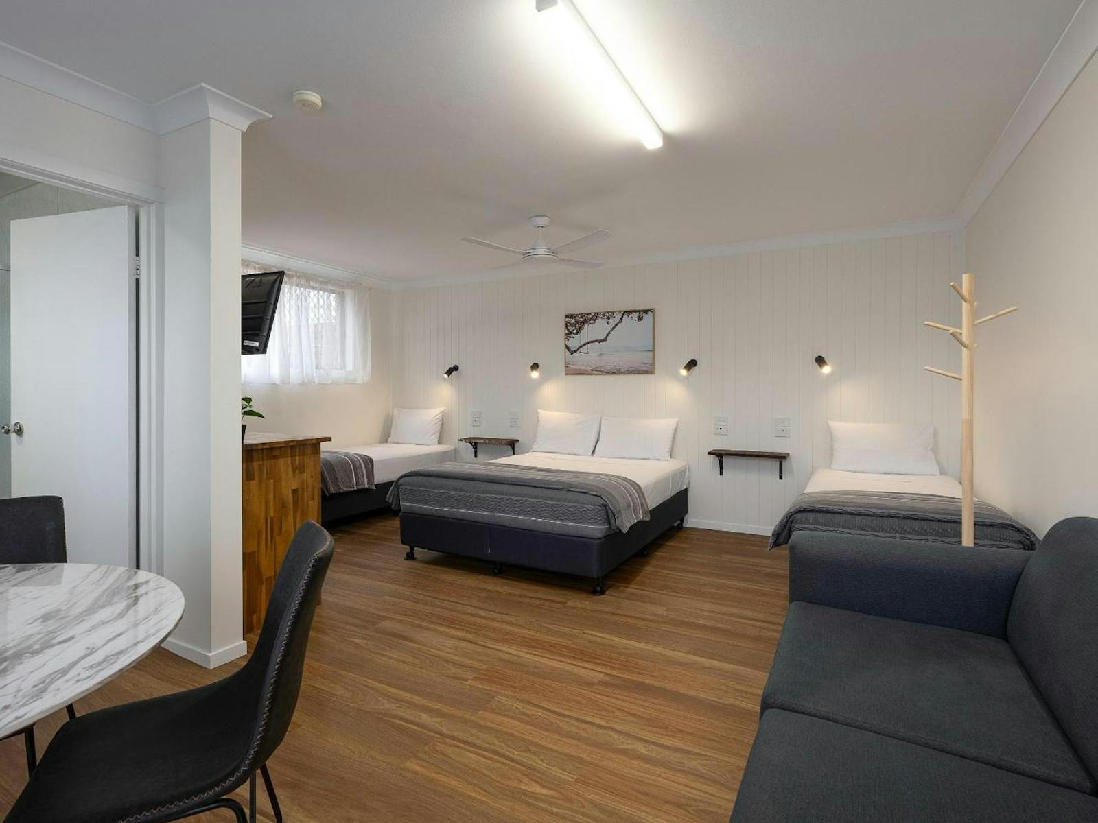 Full room view including beds, dining table, lounge and bathroom