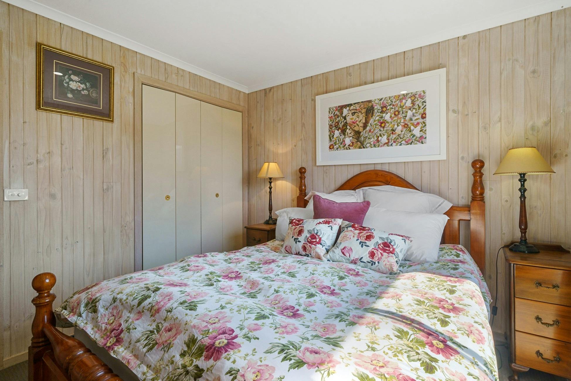 A main bedroom with a bed in the middle and floral sheets