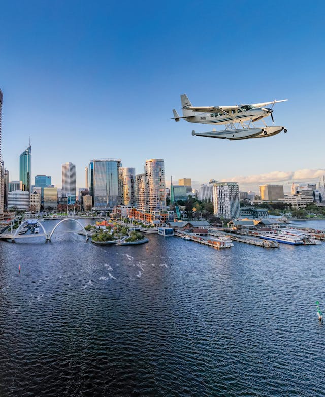 Seaplane taking off from the Swan River with Elizabeth Quay and Perth City as the backdrop