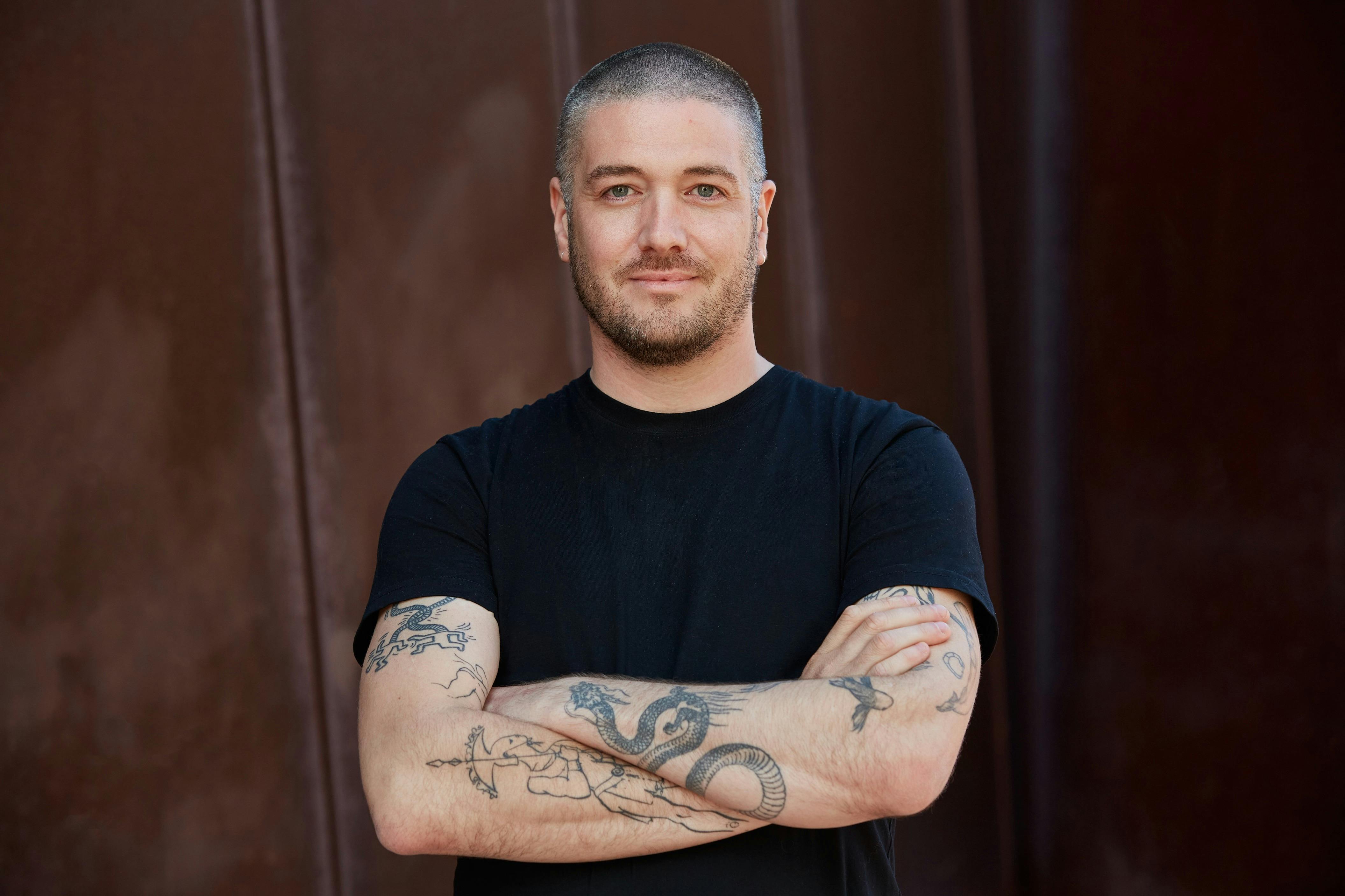 Man with arms crossed in black tshirt