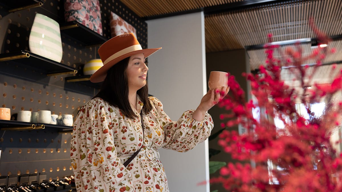 Young woman in a giftshop holding a coffee mug