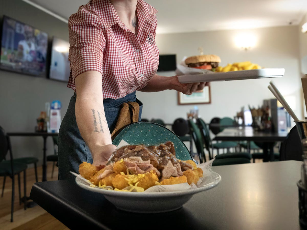 Waiter placing food on a table.