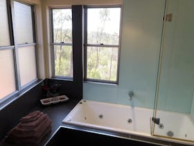large bathroom wrap around windows spa bath shower