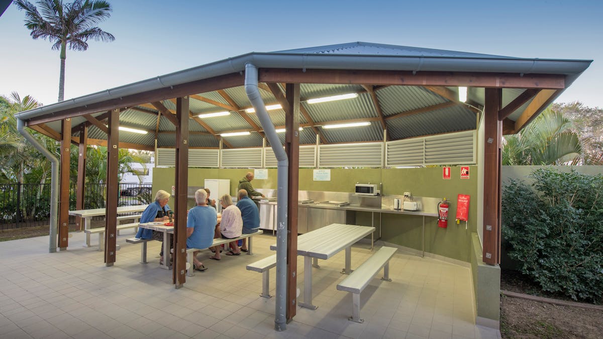 Cotton Tree Camp Kitchen wide shot with people sitting down and someone cooking Cotton Tree Camp Kitchen wide shot with people sitting down and someone cooking