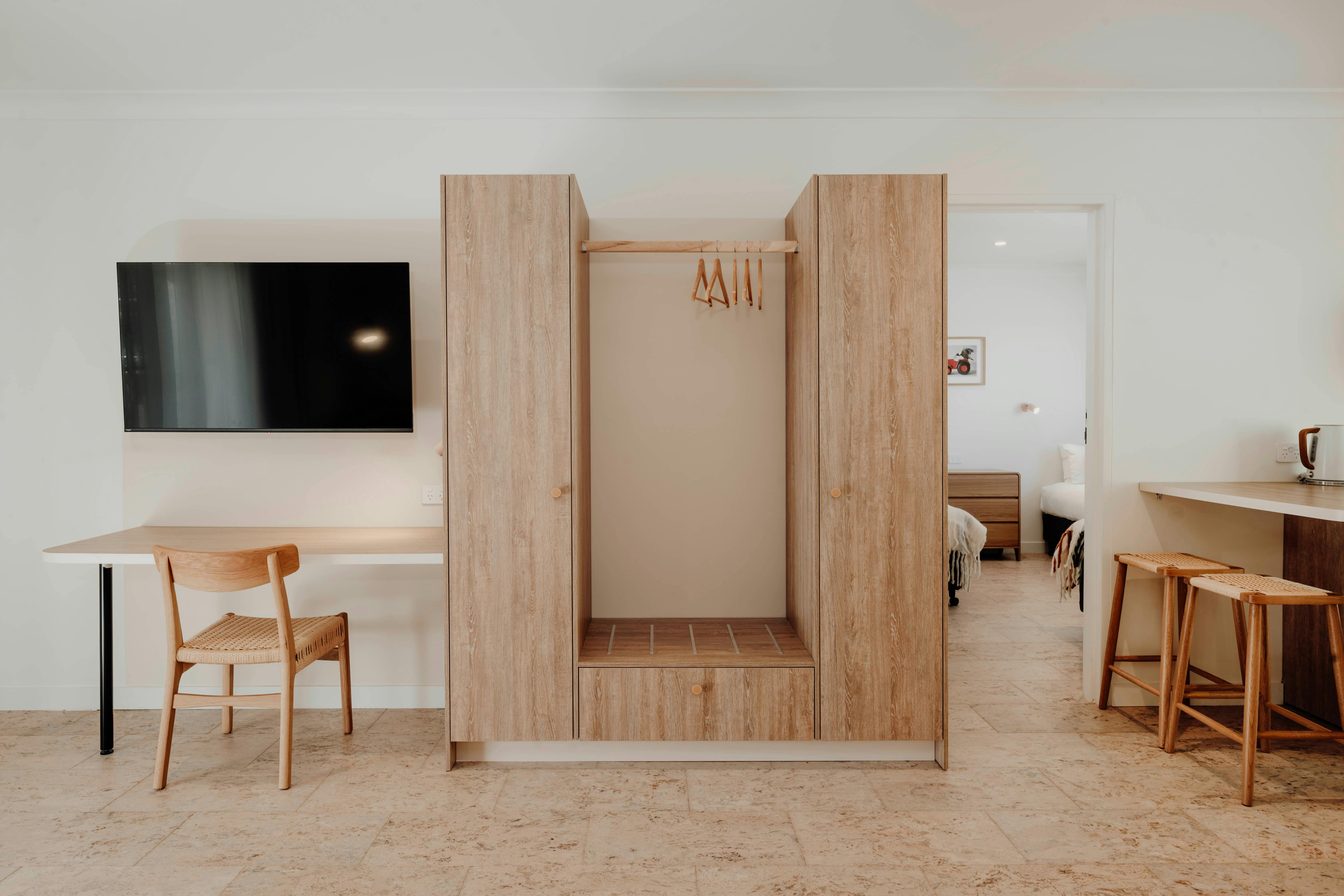 Smart wooden desk, cupboard and hanging space. View to second bedroom. Breakfast Bar.