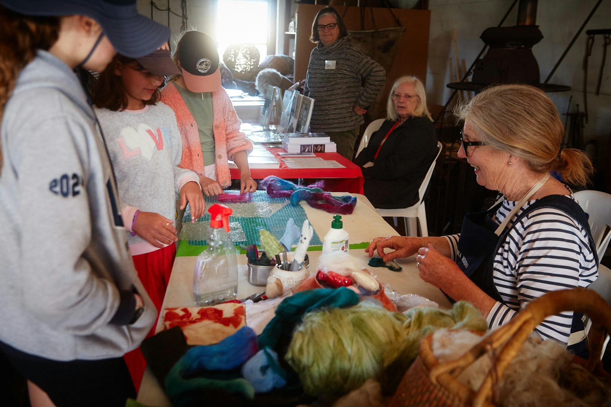 woman showcasing her work to a group of children