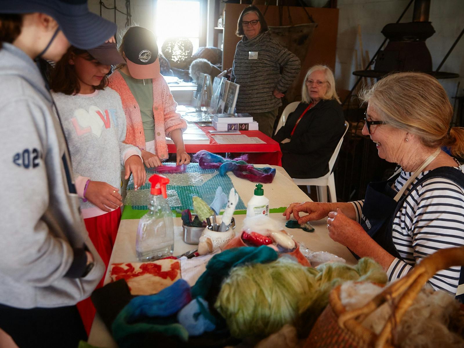 woman showcasing her work to a group of children