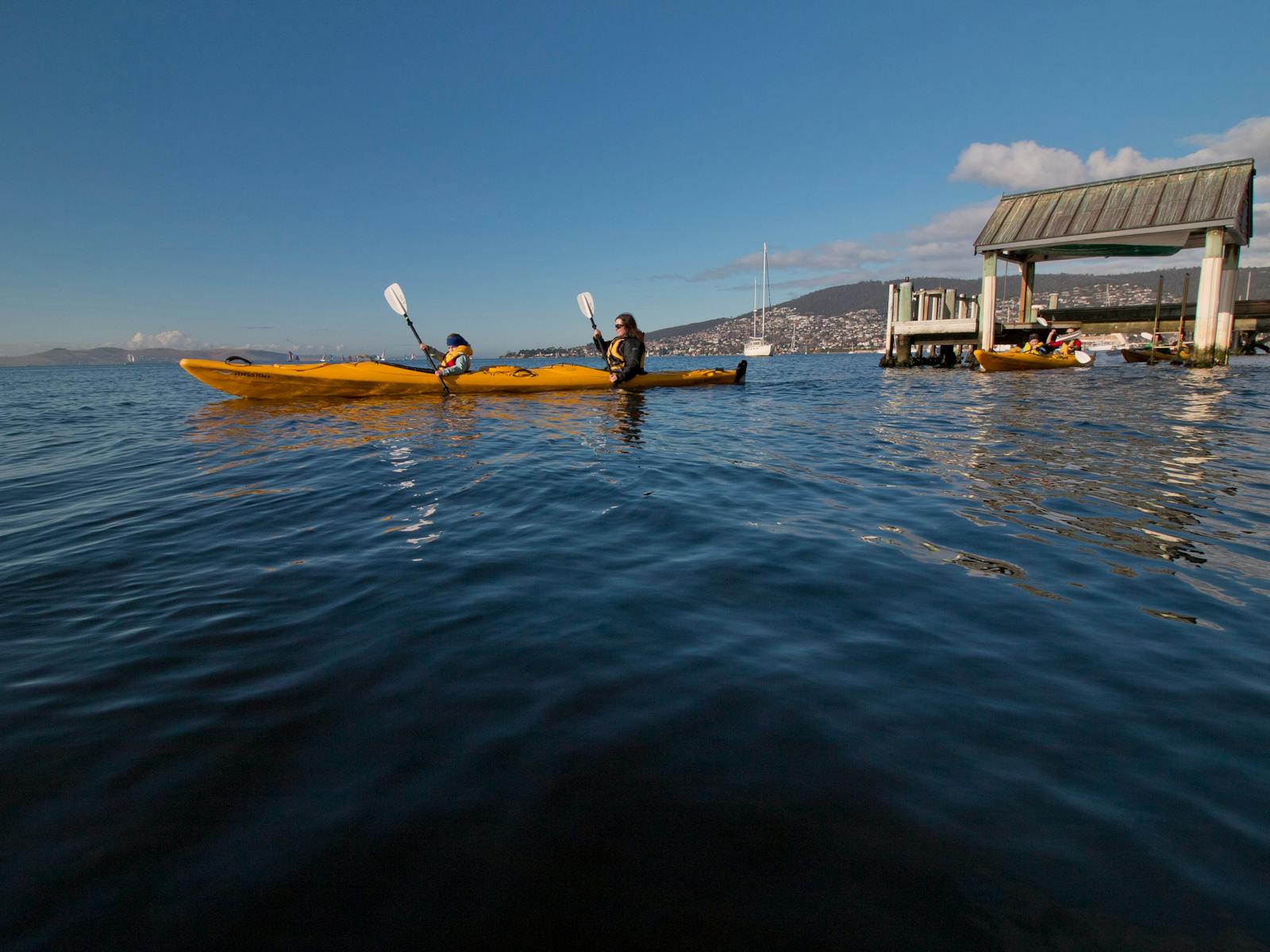 Kayakers on the Derwent River with jetties in the background