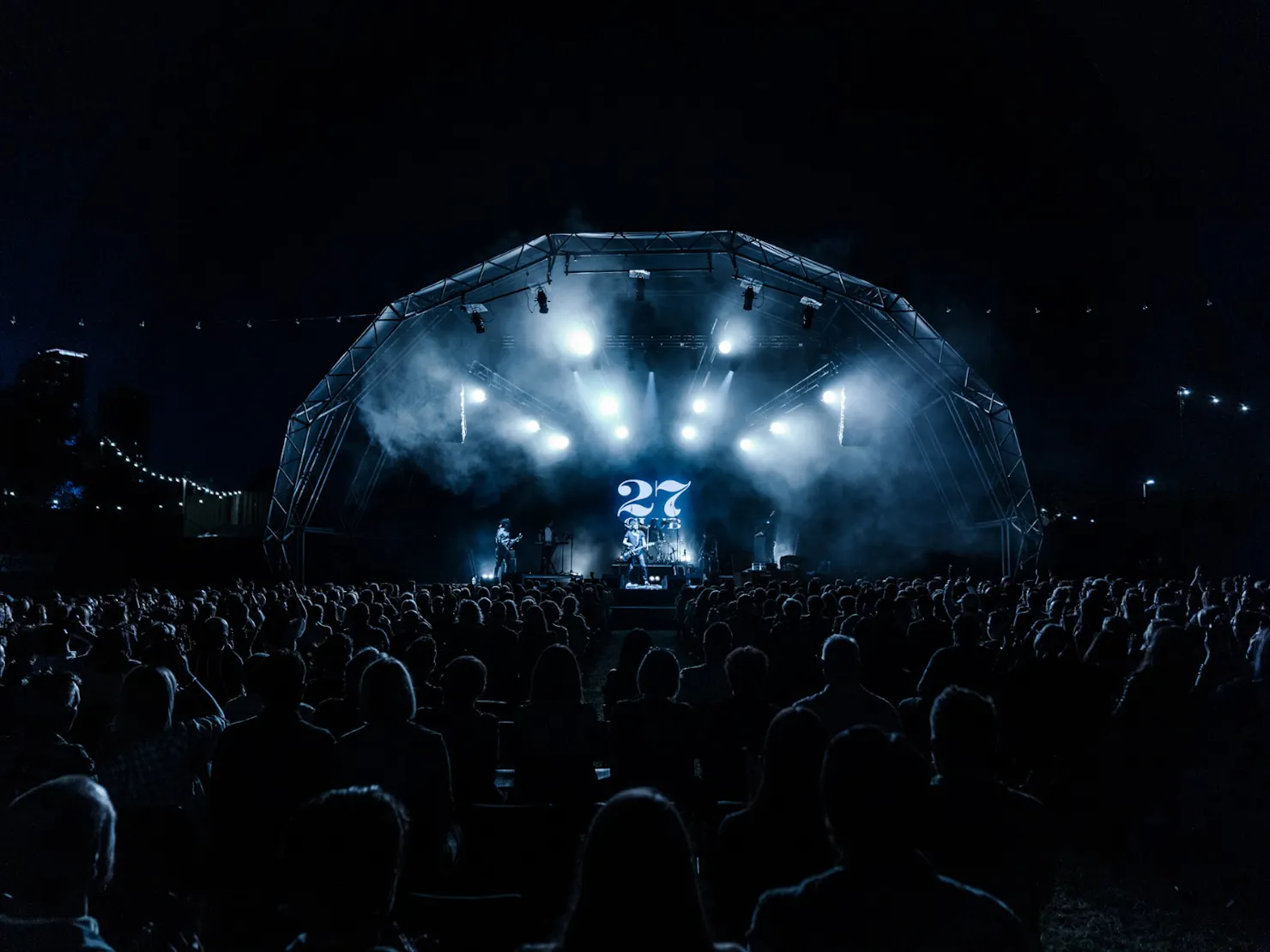 A photo from the the crowd perspective of the stage at night.