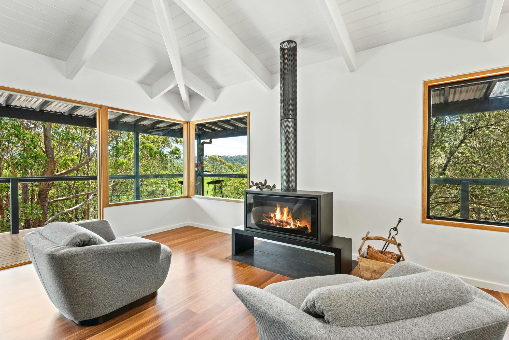 Open plan living area with fireplace leading out to wrap around verandah