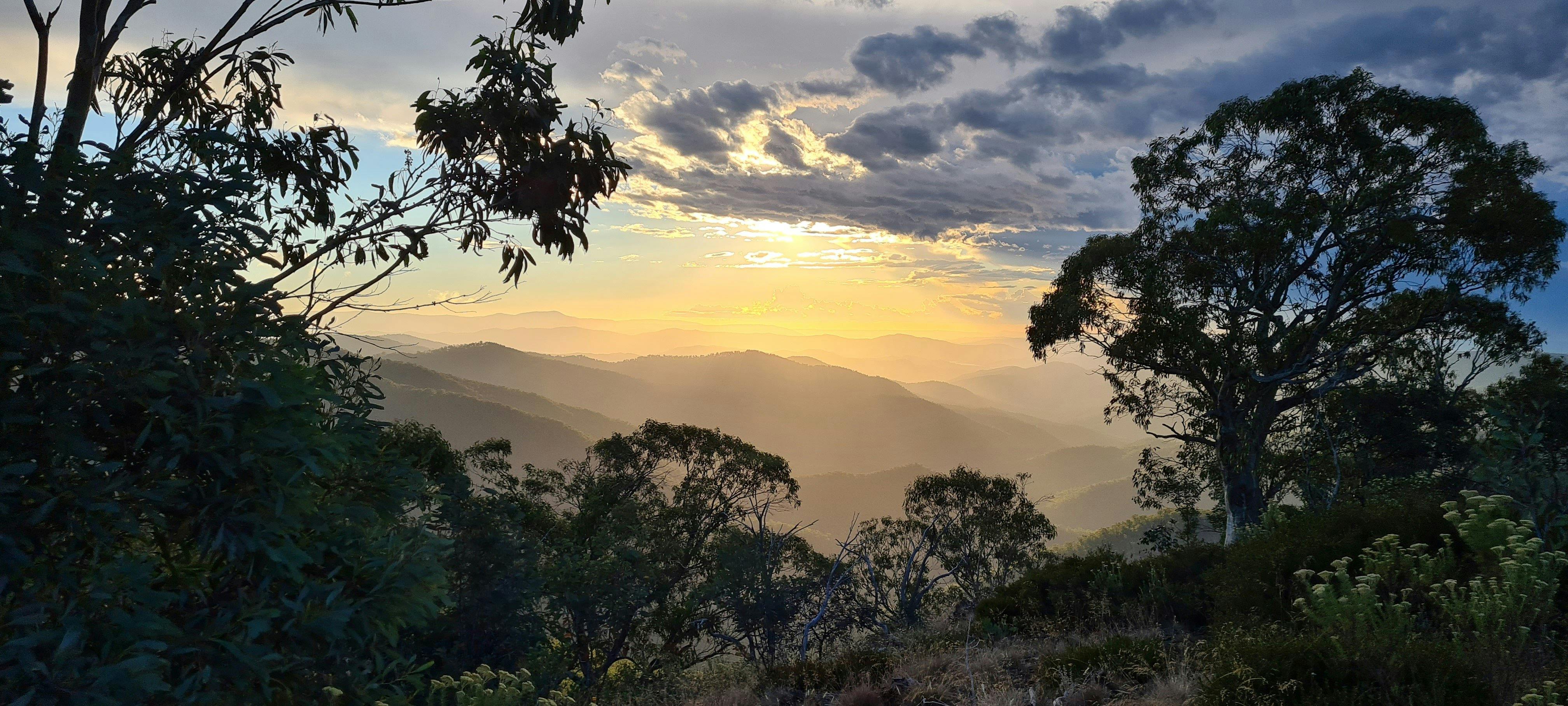 Looking West from Eagles Peaks across the mountains as the sun descends towards the horizon.