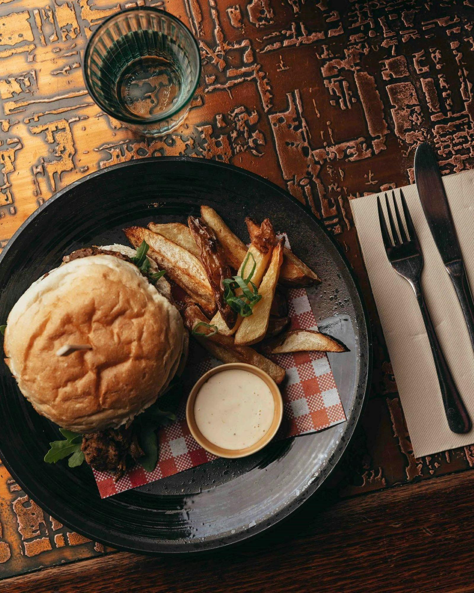 Burger and fries plated on a wooden table