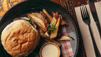 Burger and fries plated on a wooden table