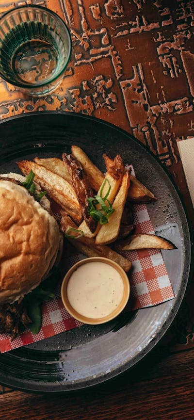 Burger and fries plated on a wooden table