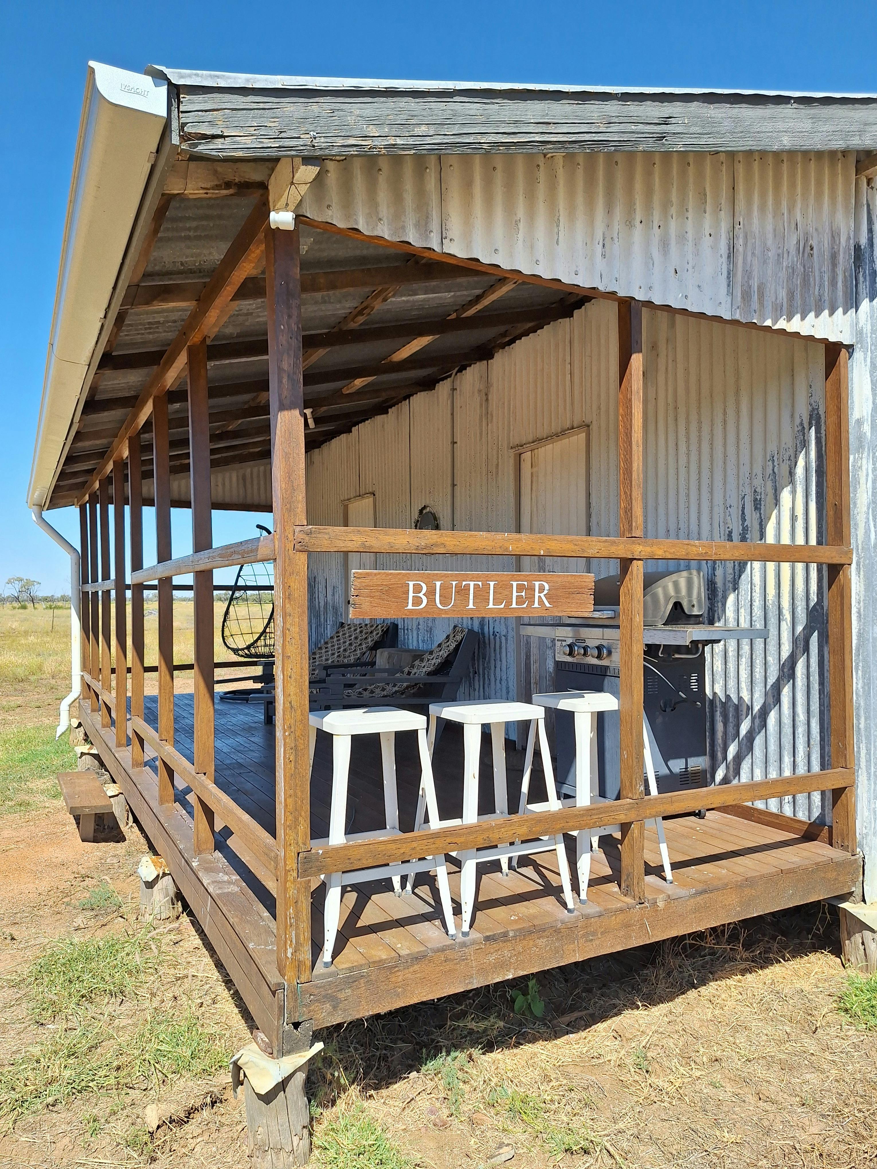 A front verandah with a bbq and stools