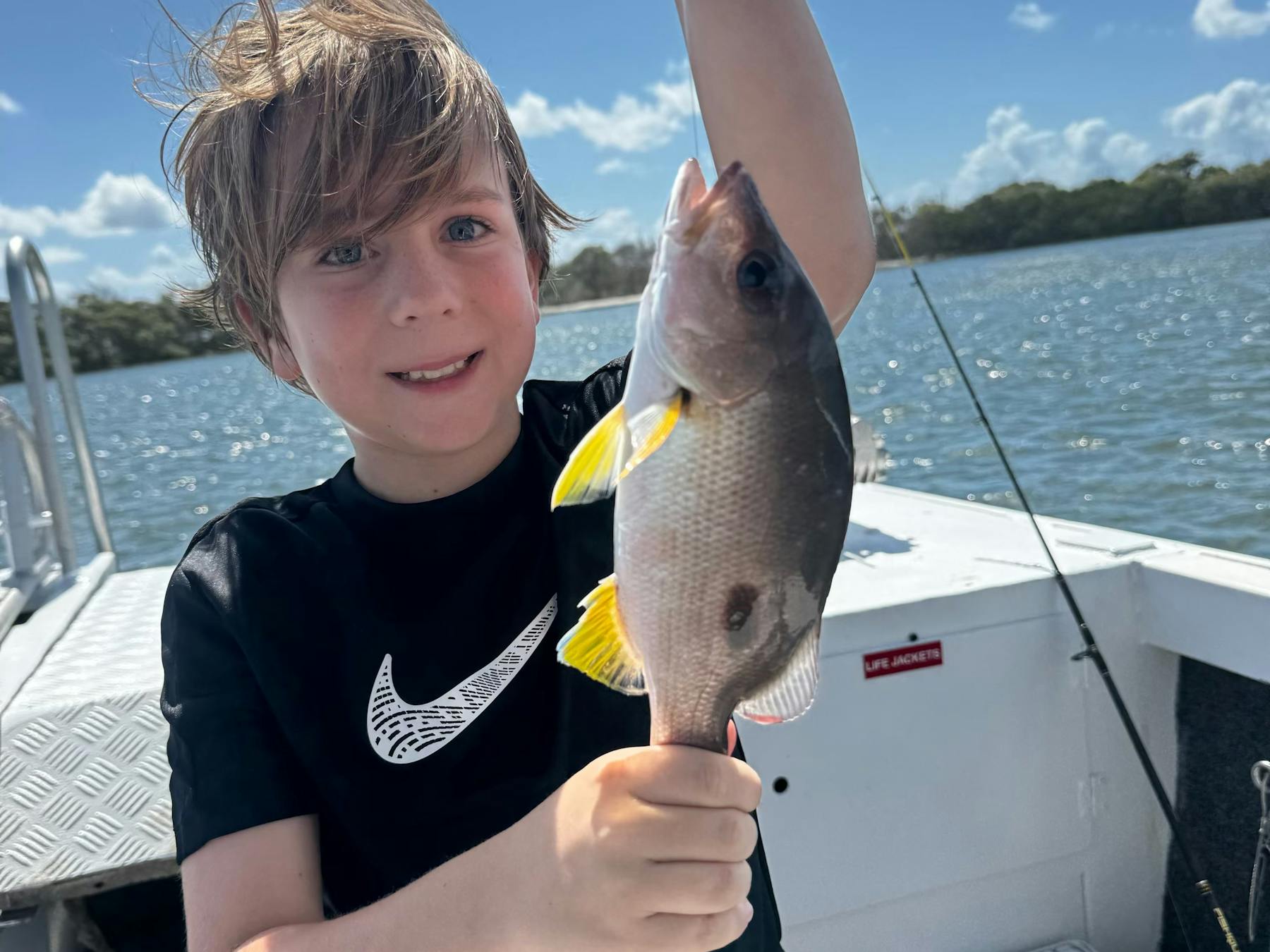 Young boy catches fish onboard Fish Moreton