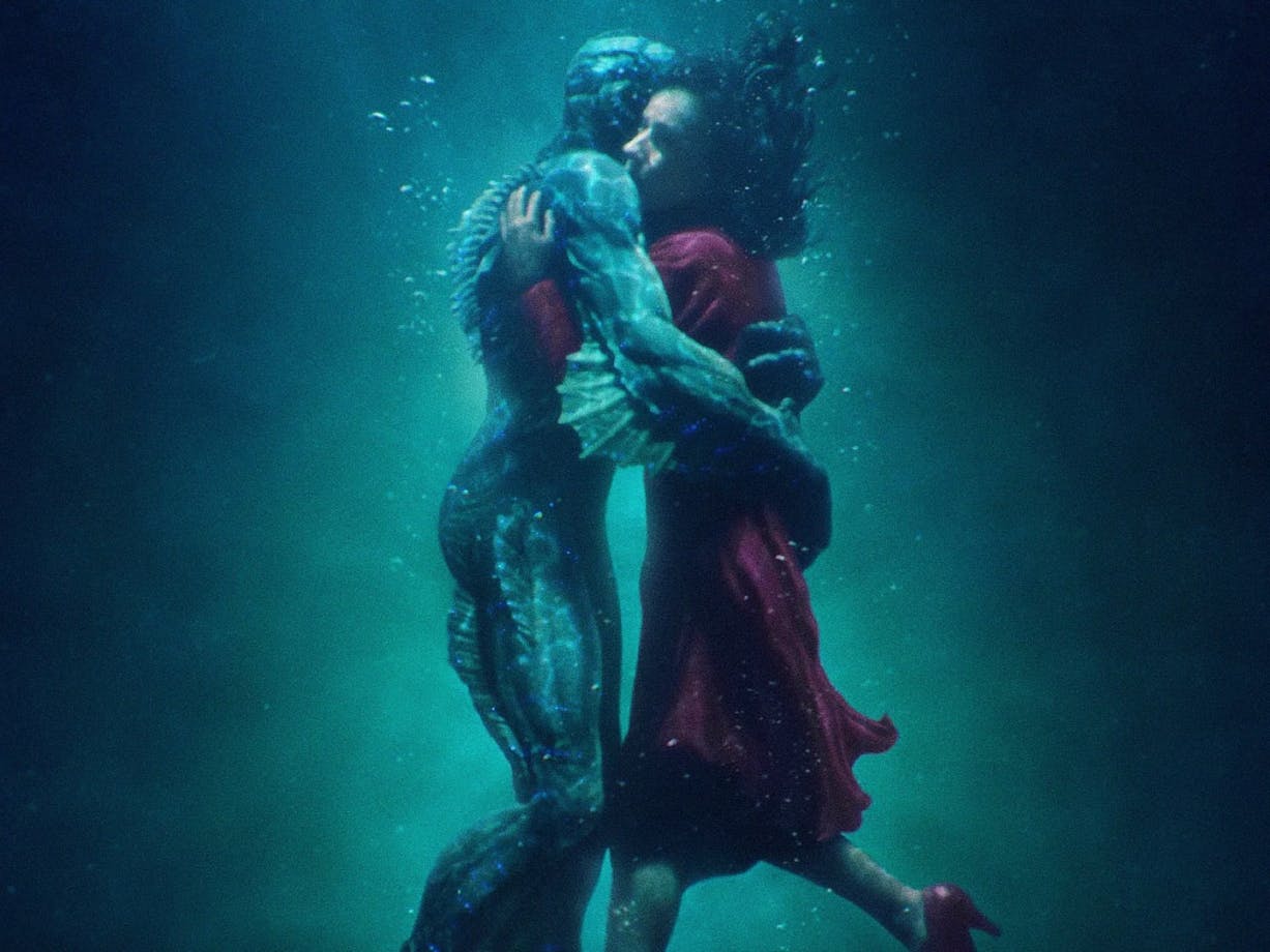 Merman and woman embracing under water