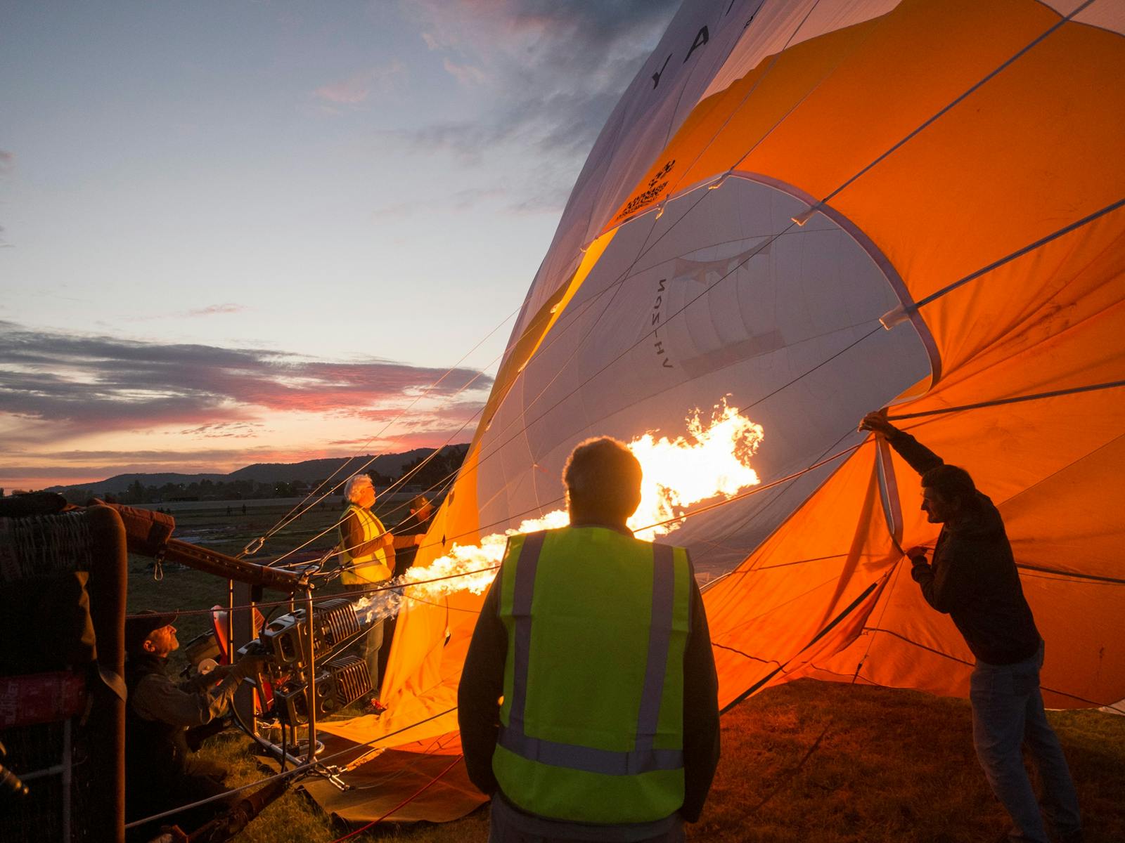 Hot air balloon lying on its side as the inflation progresses. Burners heat the air up to create lif