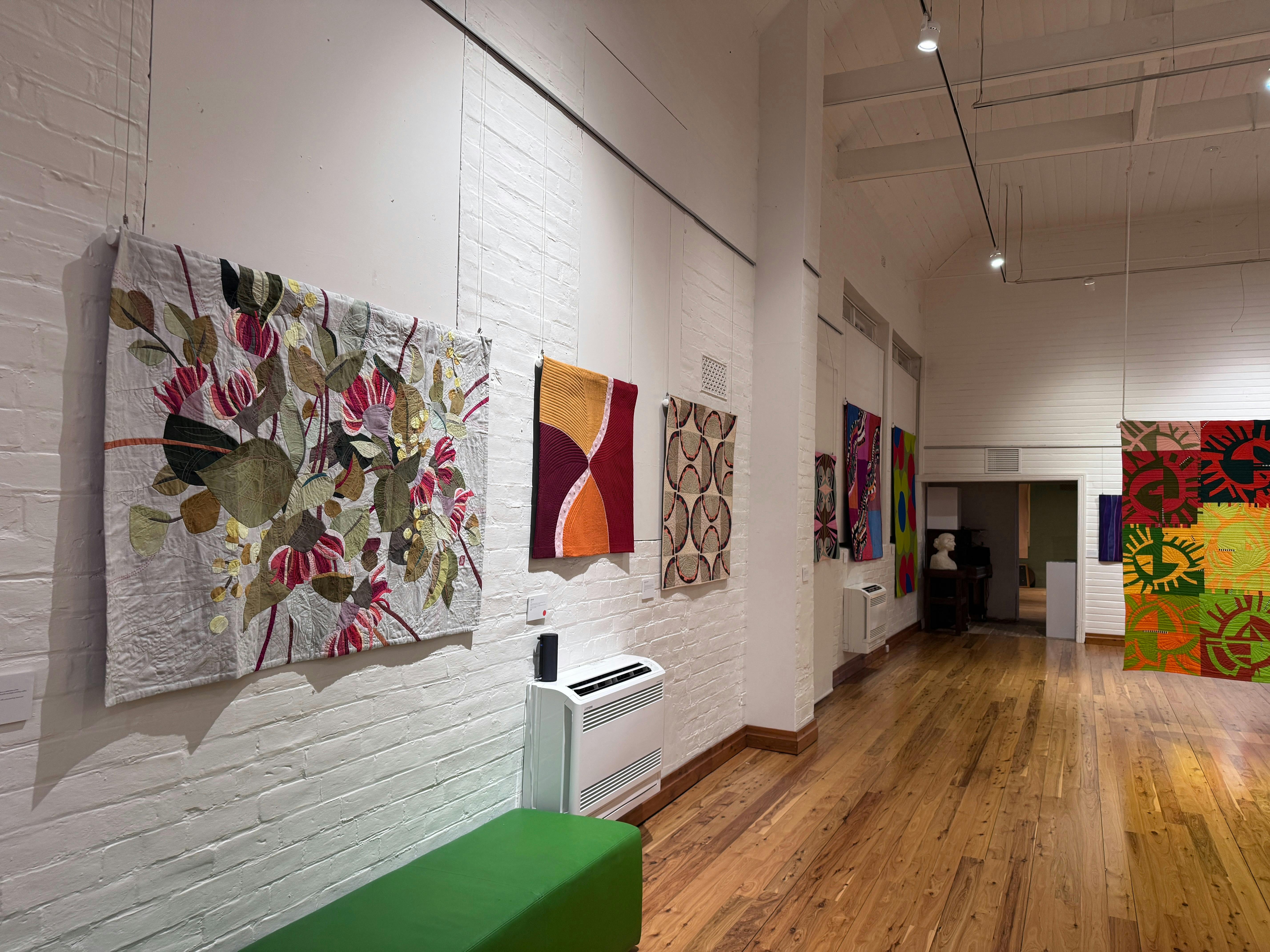 Quilts hängen an einer weißen Wand