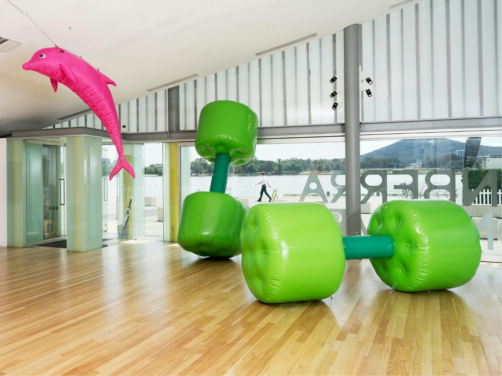 Larger than life green dumbbells and pink dolphin.