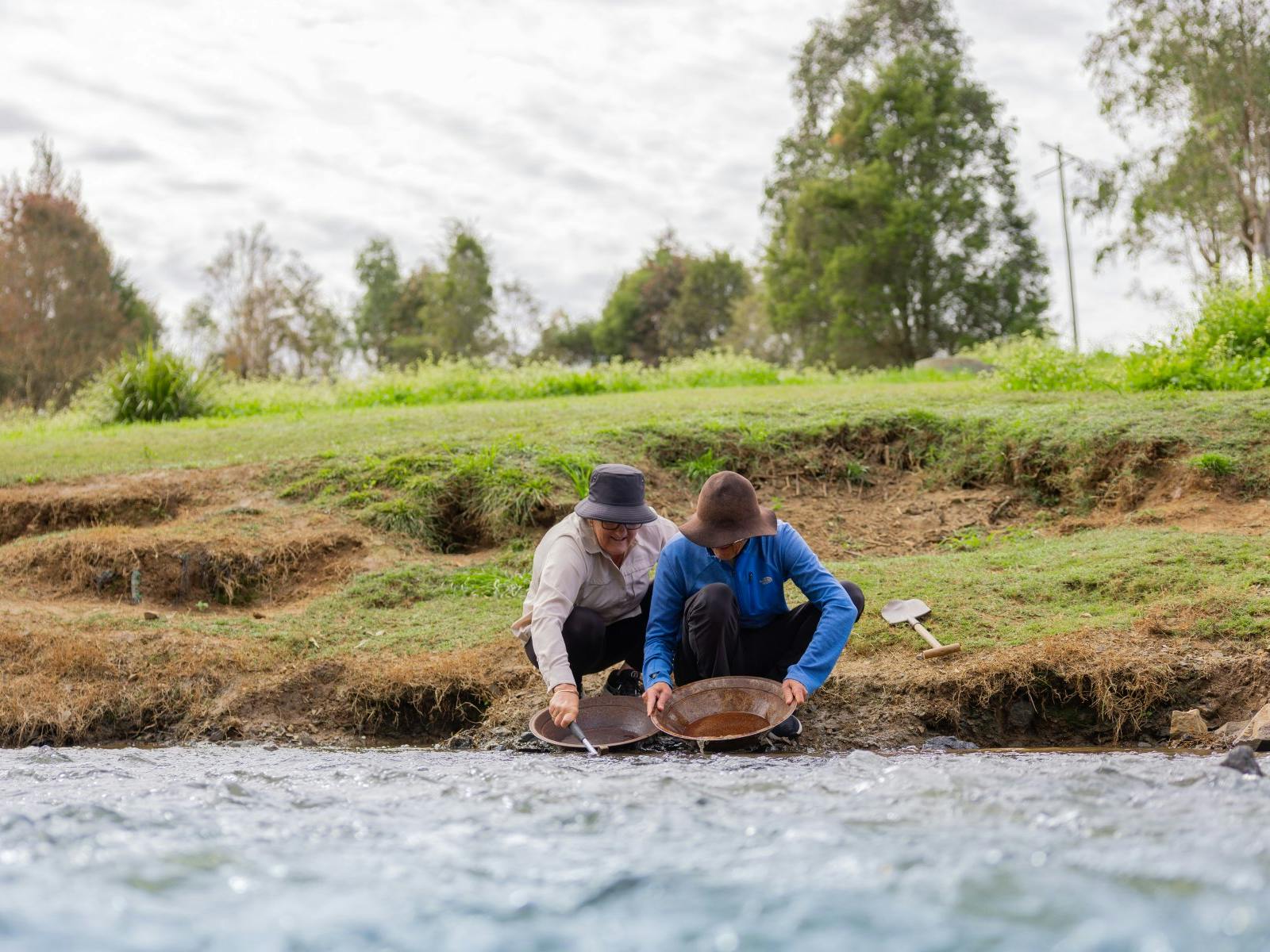 A couple panning for gold in the creek A couple panning for gold in the creek