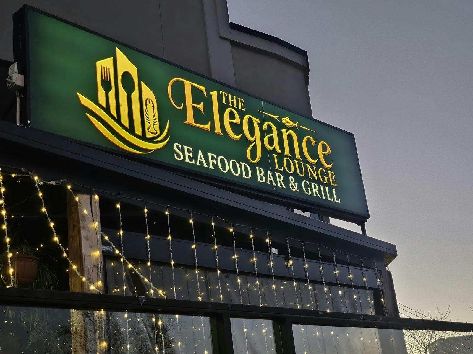 Exterior of The Elegance Lounge – Seafood Bar & Grill in Devonport, featuring the illuminated green