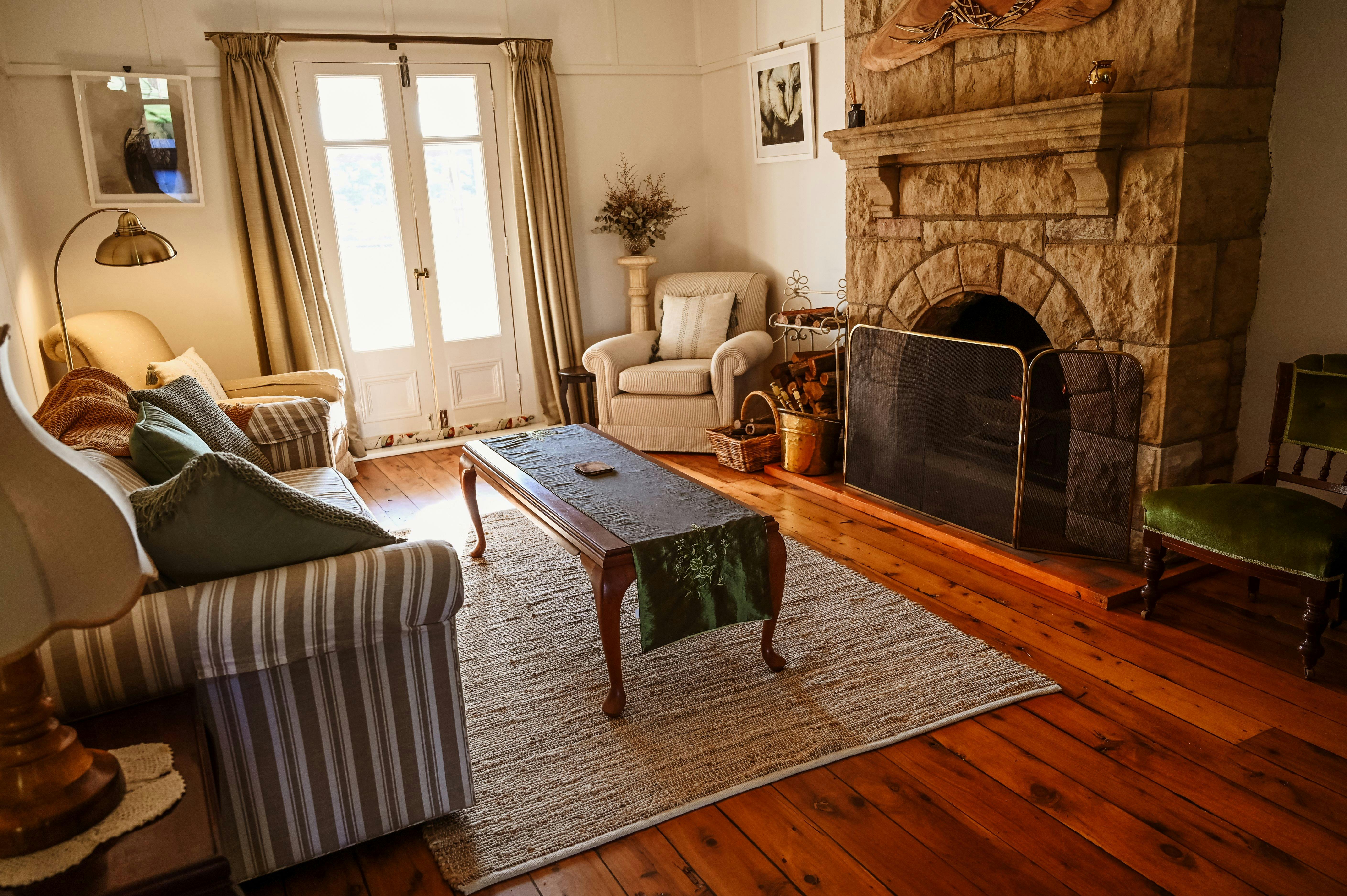 Peaceful space with stone open fireplace, antique furnishing paying homage to this historic home