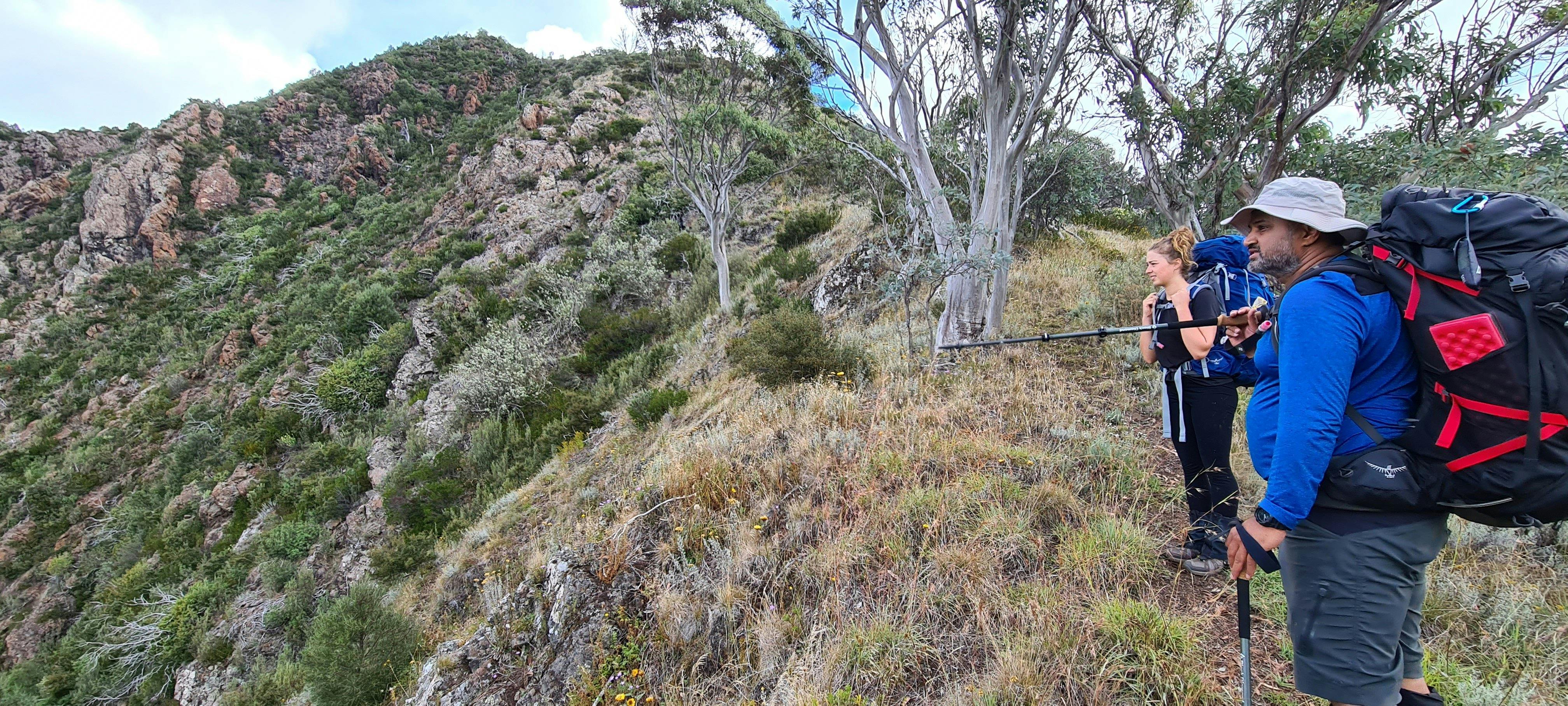 A couple of hikers taking in the views from the ridge with final destination in sight.