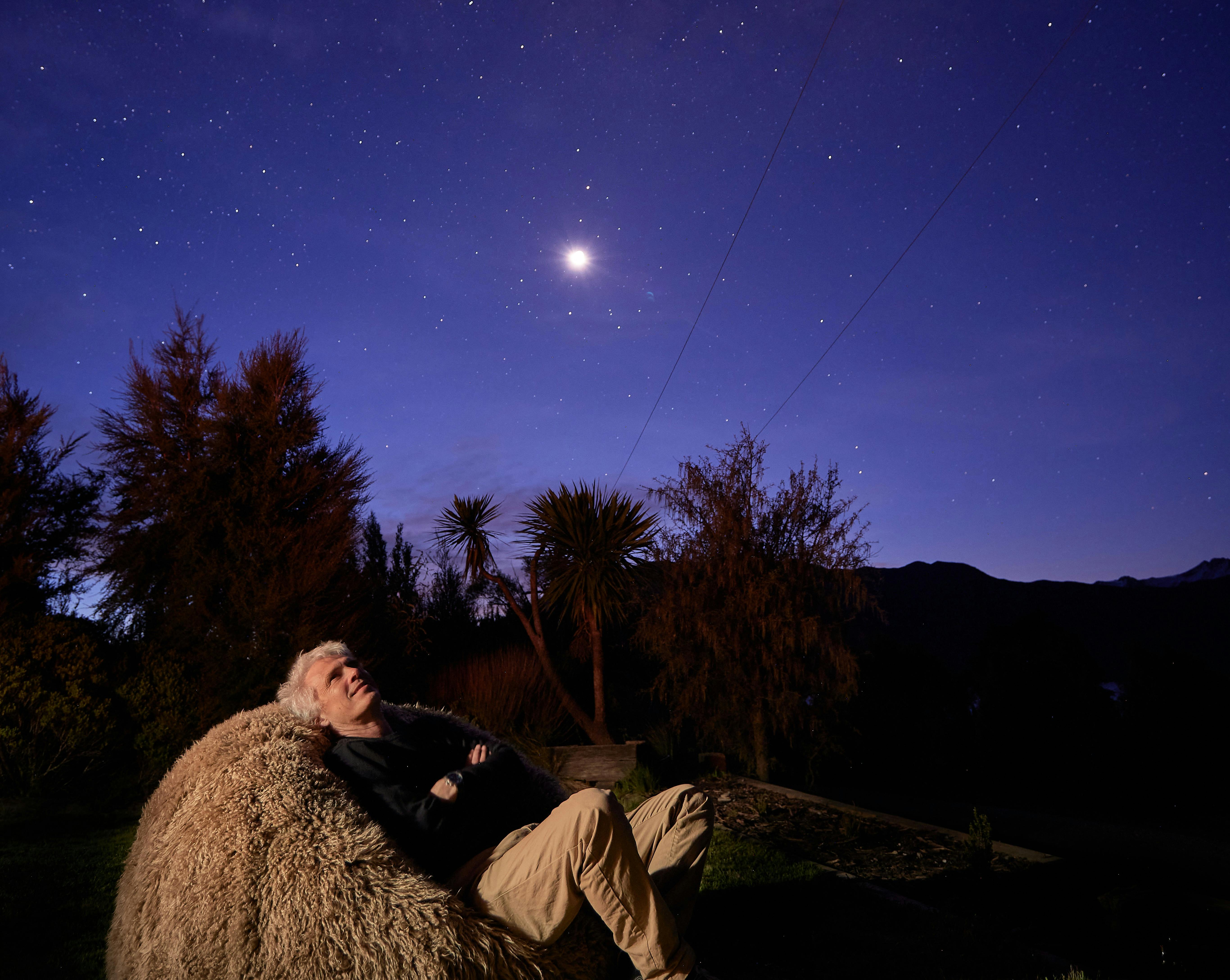 Man looking up at the dtars on a shaggy Wilson & Dorset sheepskin bean bag
