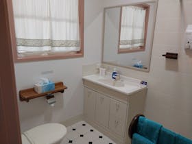 Bathroom has a toilet, shower, towels, hair dryer, shampoo and hand/body soap.