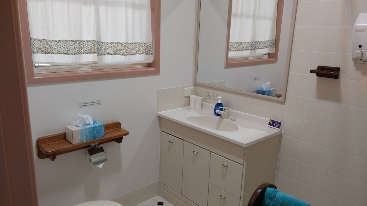 Bathroom has a toilet, shower, towels, hair dryer, shampoo and hand/body soap.