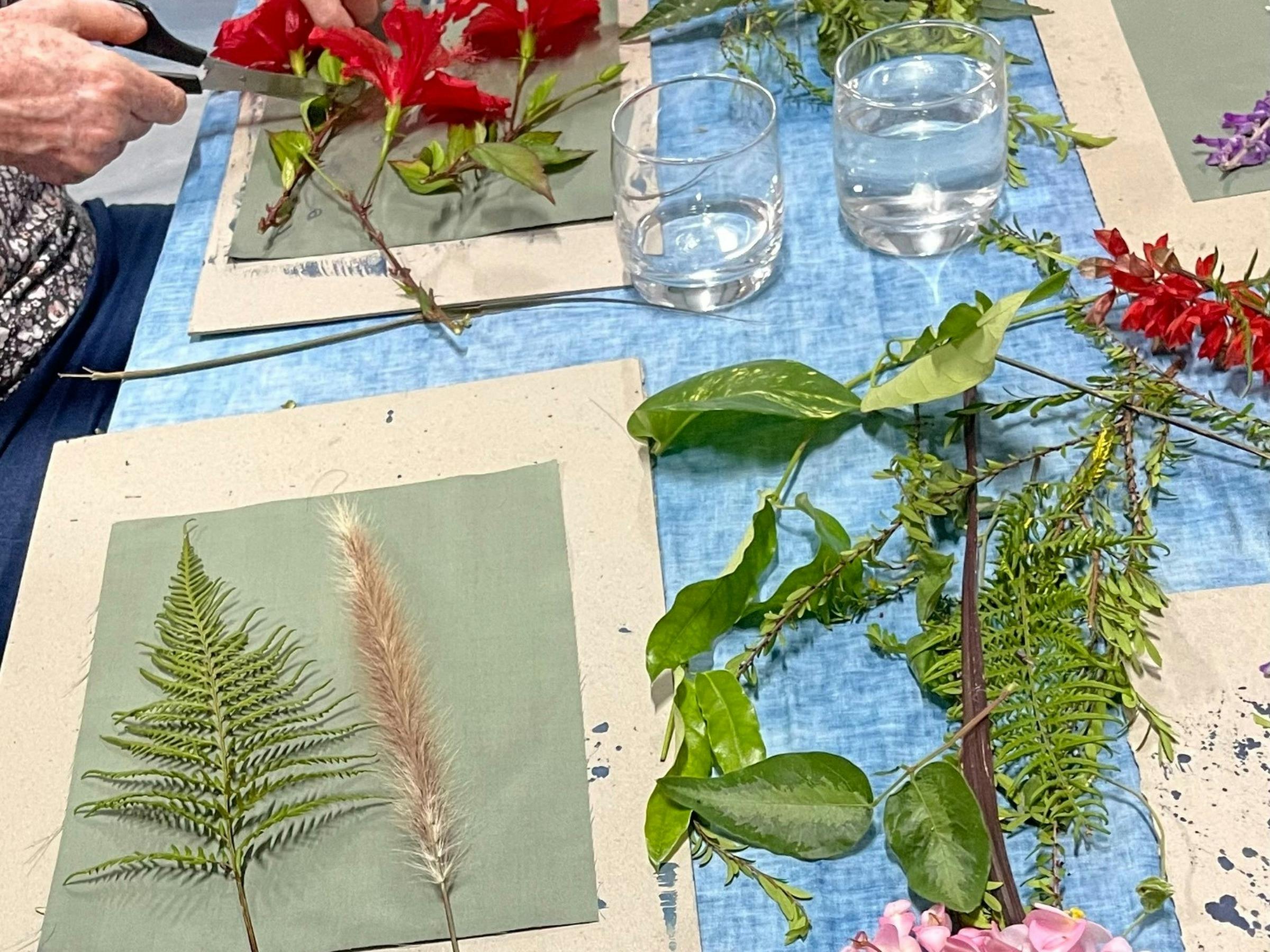 Blue-and-white botanical cyanotype prints featuring detailed silhouettes of ferns, flowers, leaves