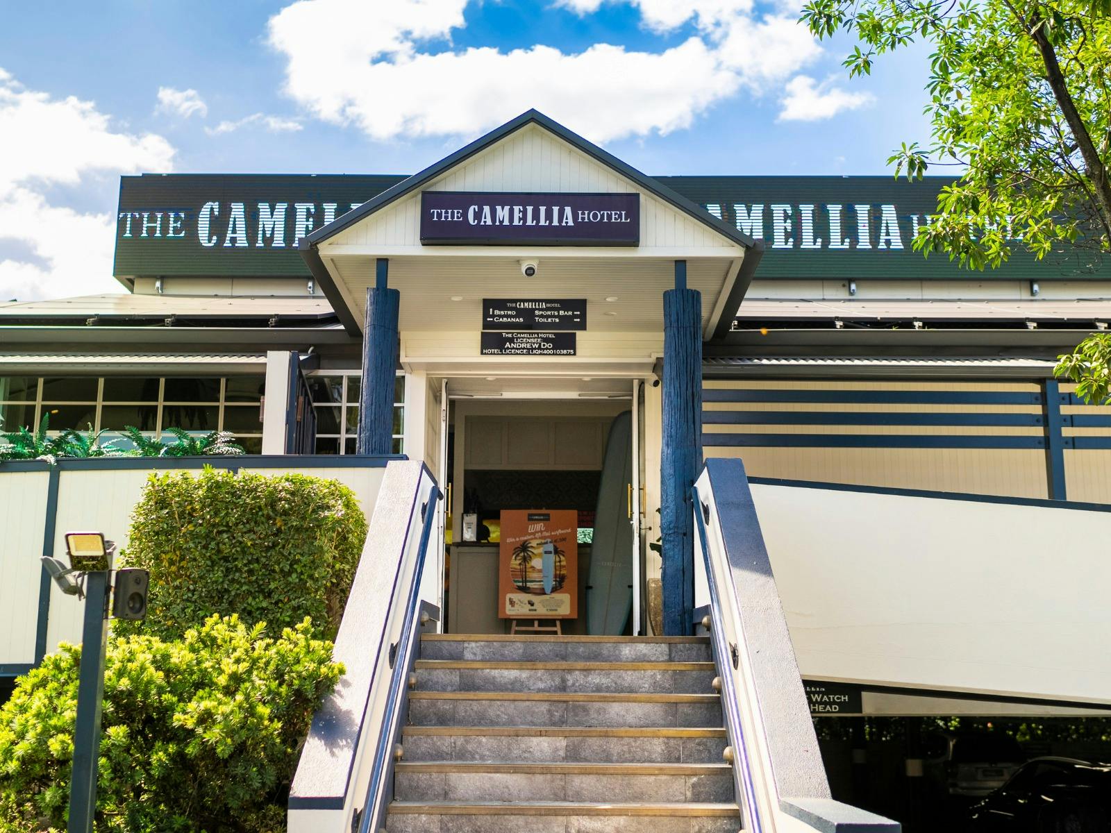 entrance of The Camellia Hotel with stairs and signage in frame