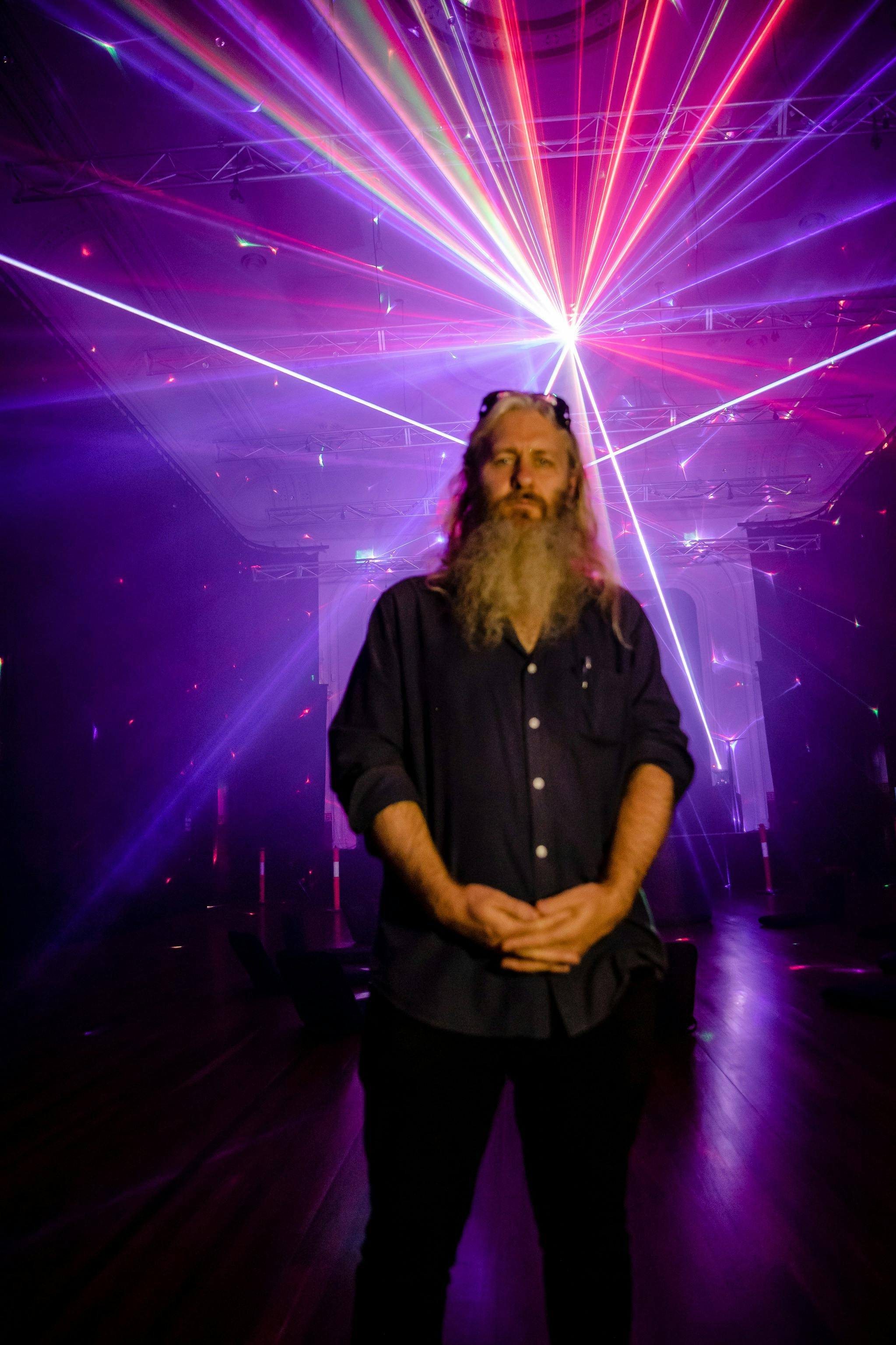 Artist Robin Fox pictured in front of a detail of his artwork