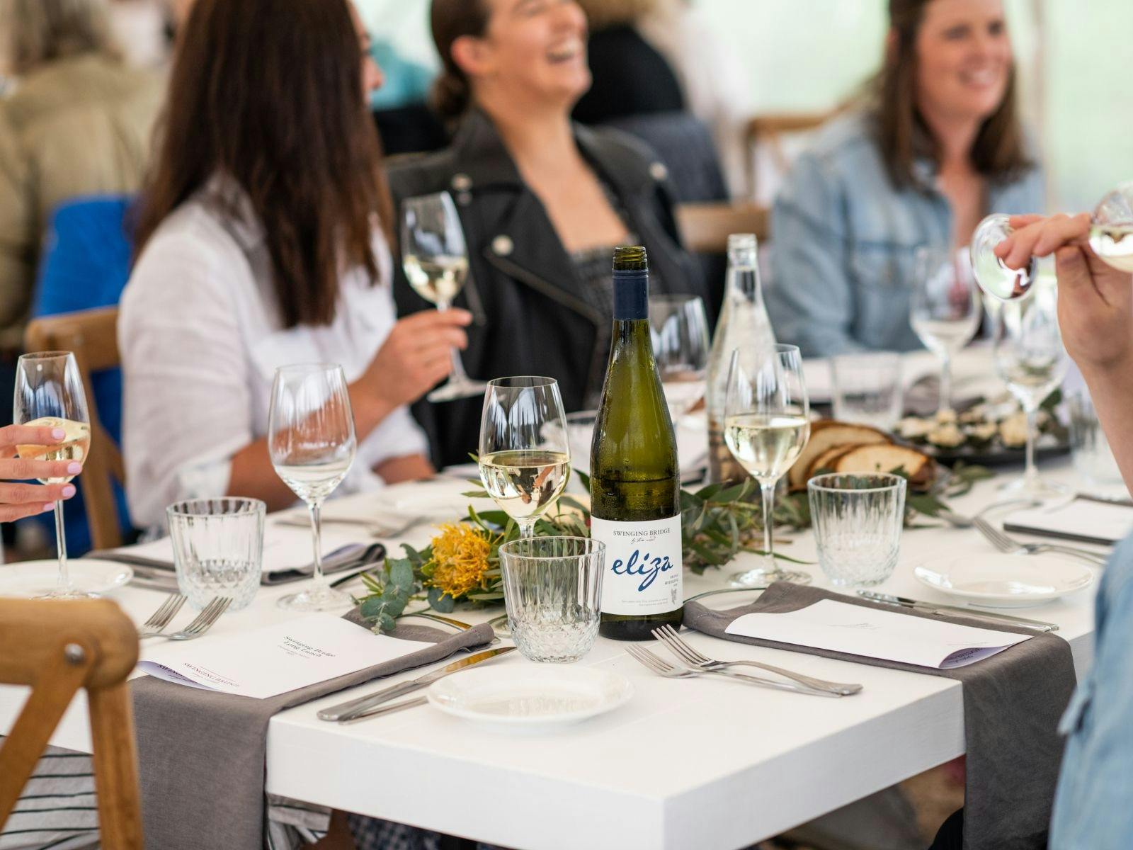 오렌지의 세련된 분위기 속에서 낮에 모임을 갖고 스윙잉 브리지 와인을 즐기는 손님들.