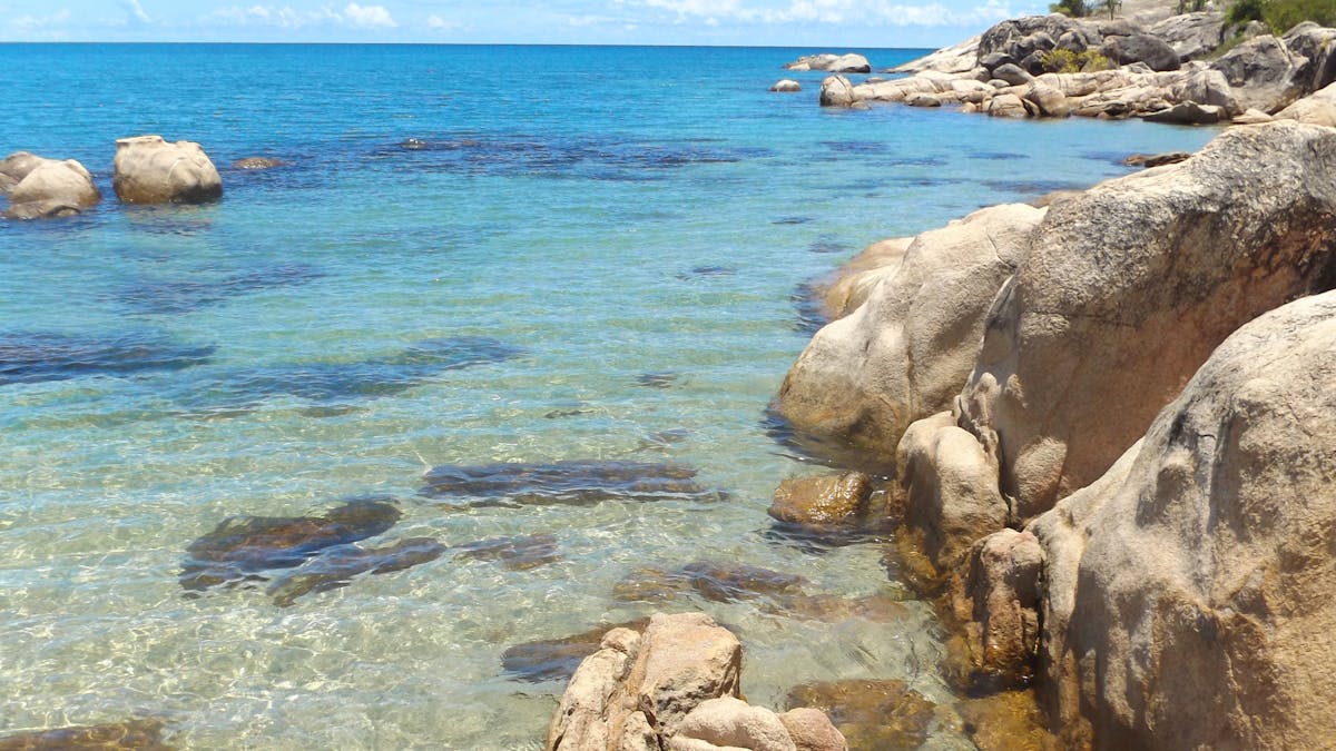 Granite rocks, clear blue water in sheltered bay
