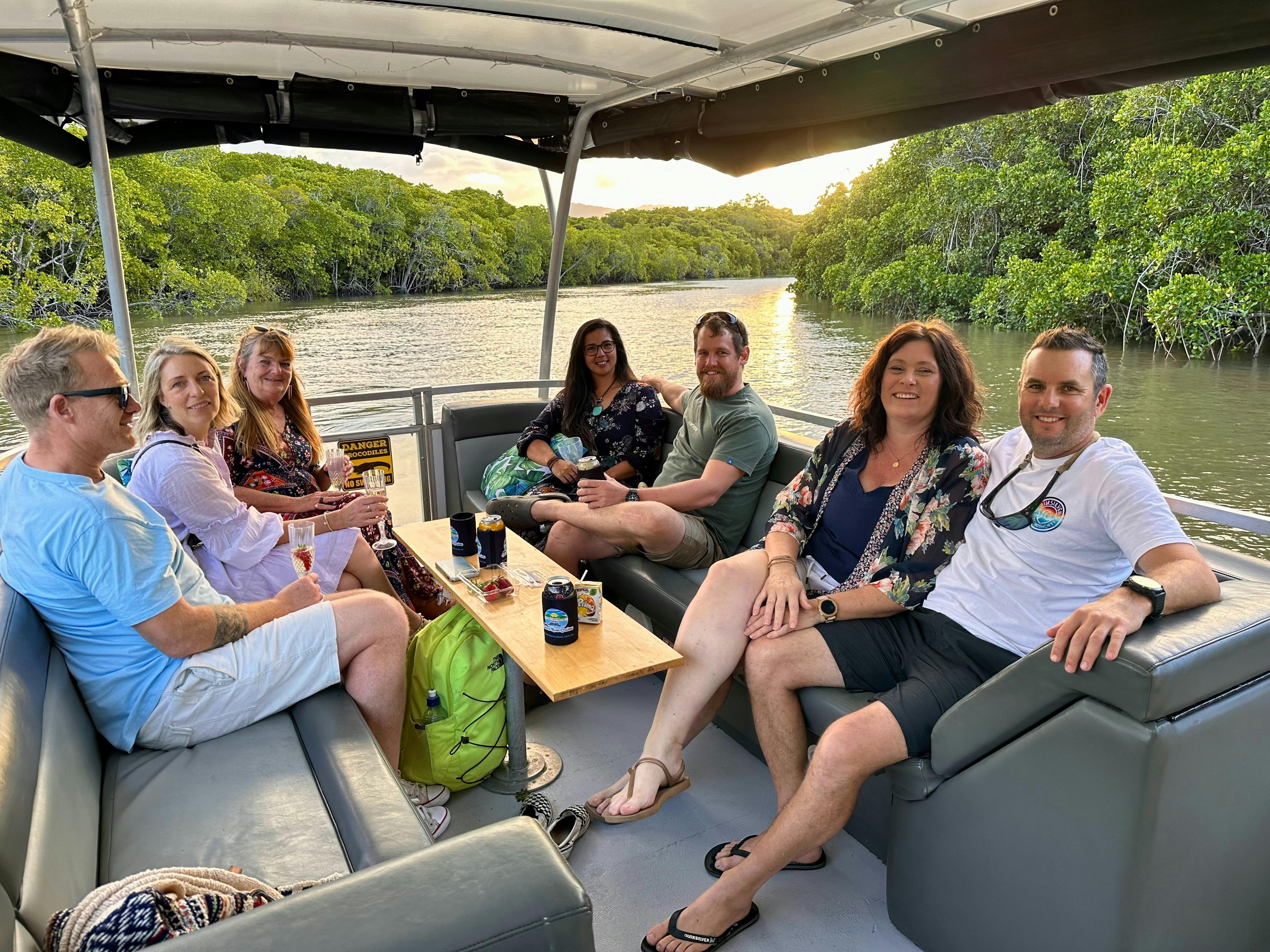 Group of 7 smiling as they enjoy an evening exploring the Trinity Inlet