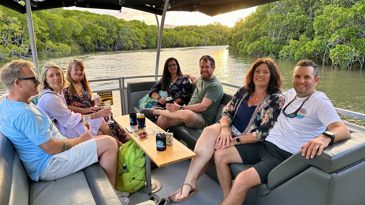 Group of 7 smiling as they enjoy an evening exploring the Trinity Inlet