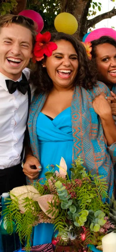 Nine people pictured smiling and laughing at camera celebrating