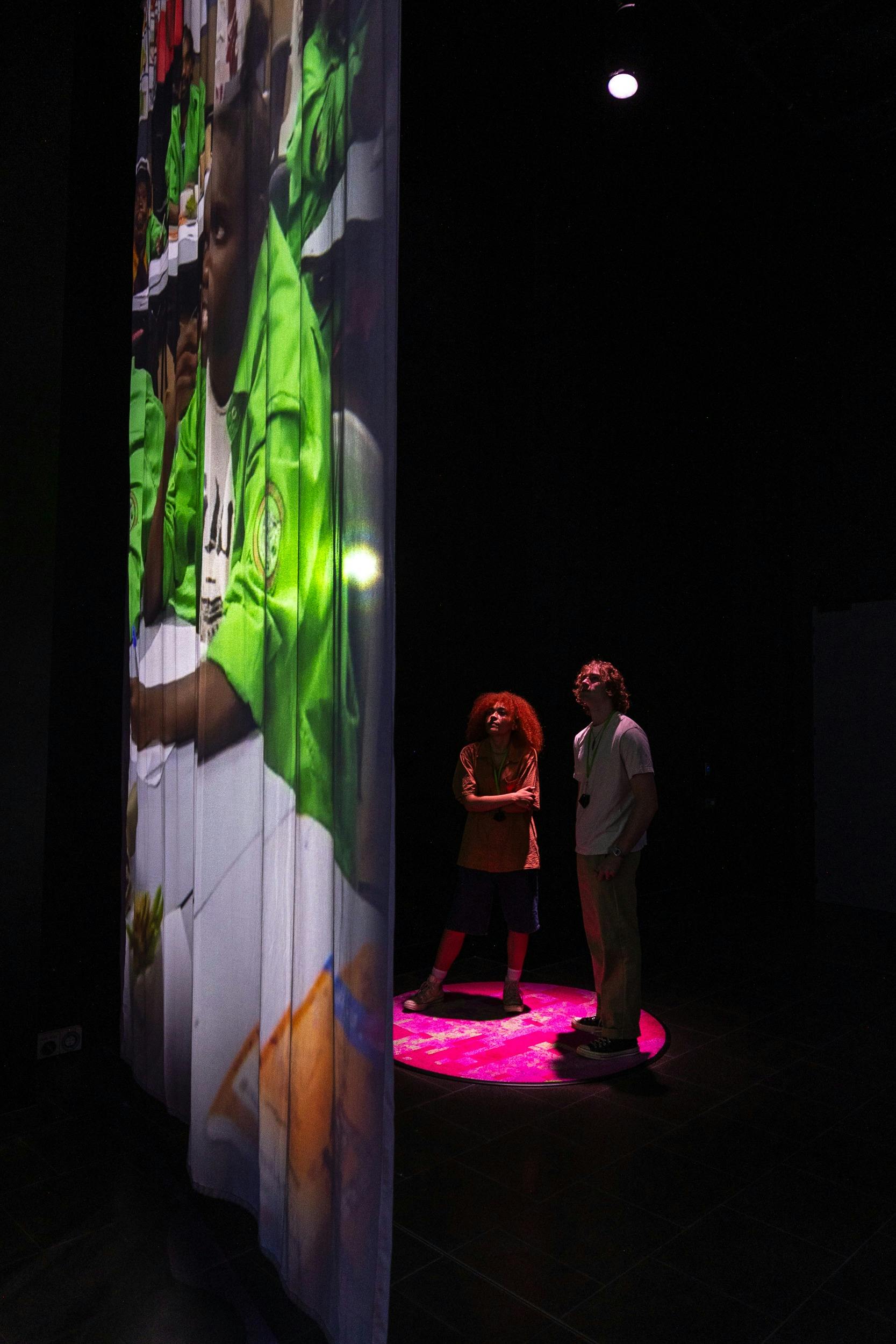 two people stand in front of a scrim