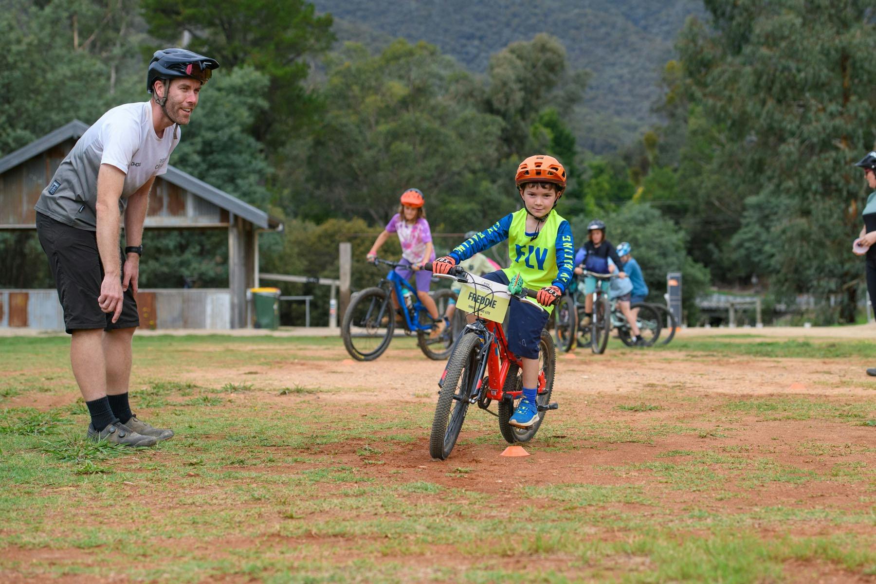 A young rider is watched by a coach