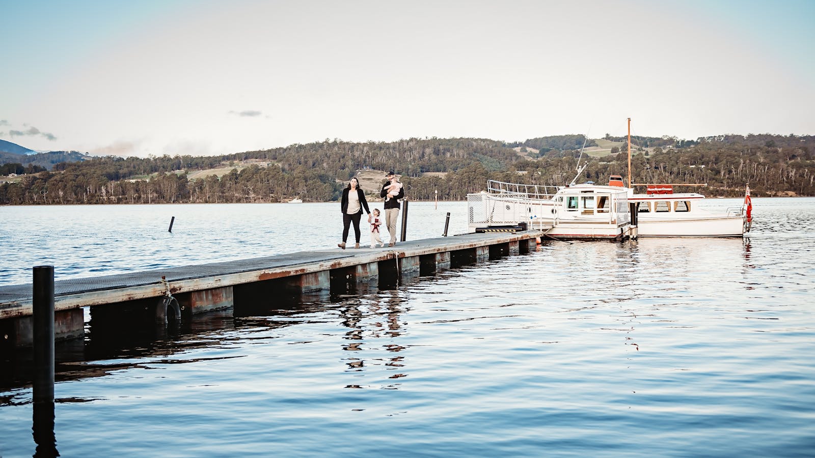 A Beautiful young family walking up the dock after a cruise on the Huon River