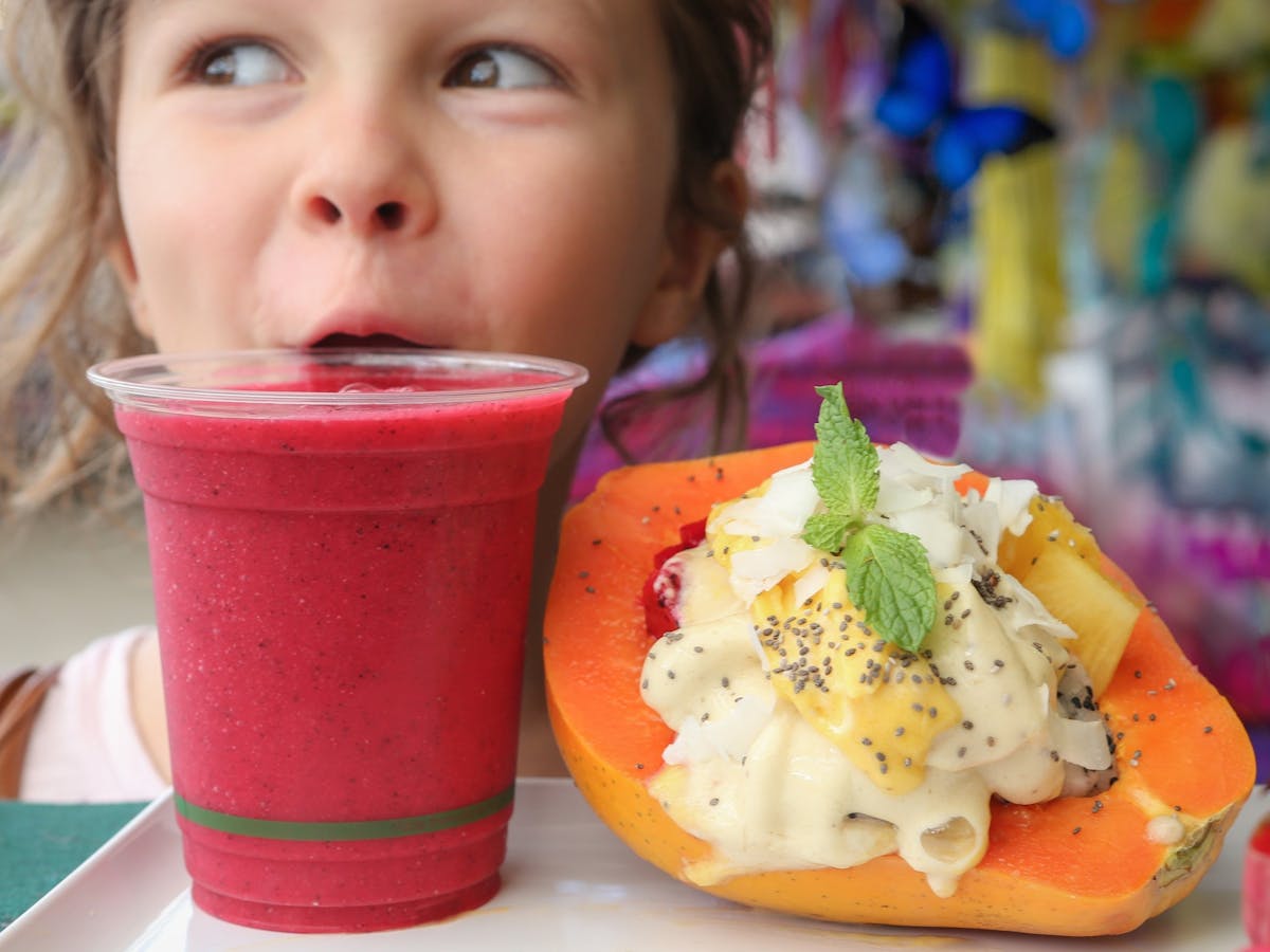 A girl sips a berry smoothie in Kuranda, Tropical North Queensland.