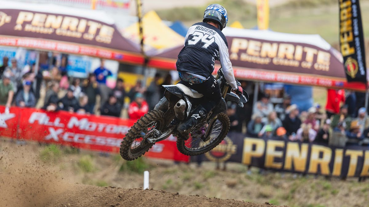 A rider soars through the air while spectators watch on in the background