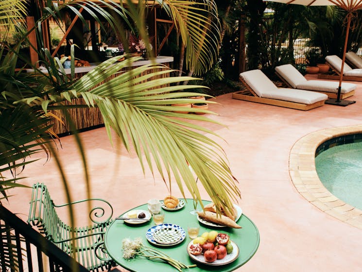 Tropical palm fronds hang over the pool at The Sunseeker, Byron Bay