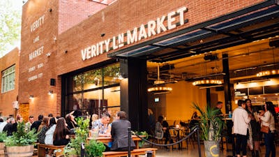 Outdoor deck with people sitting at bar tables