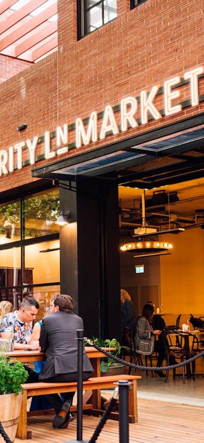 Outdoor deck with people sitting at bar tables