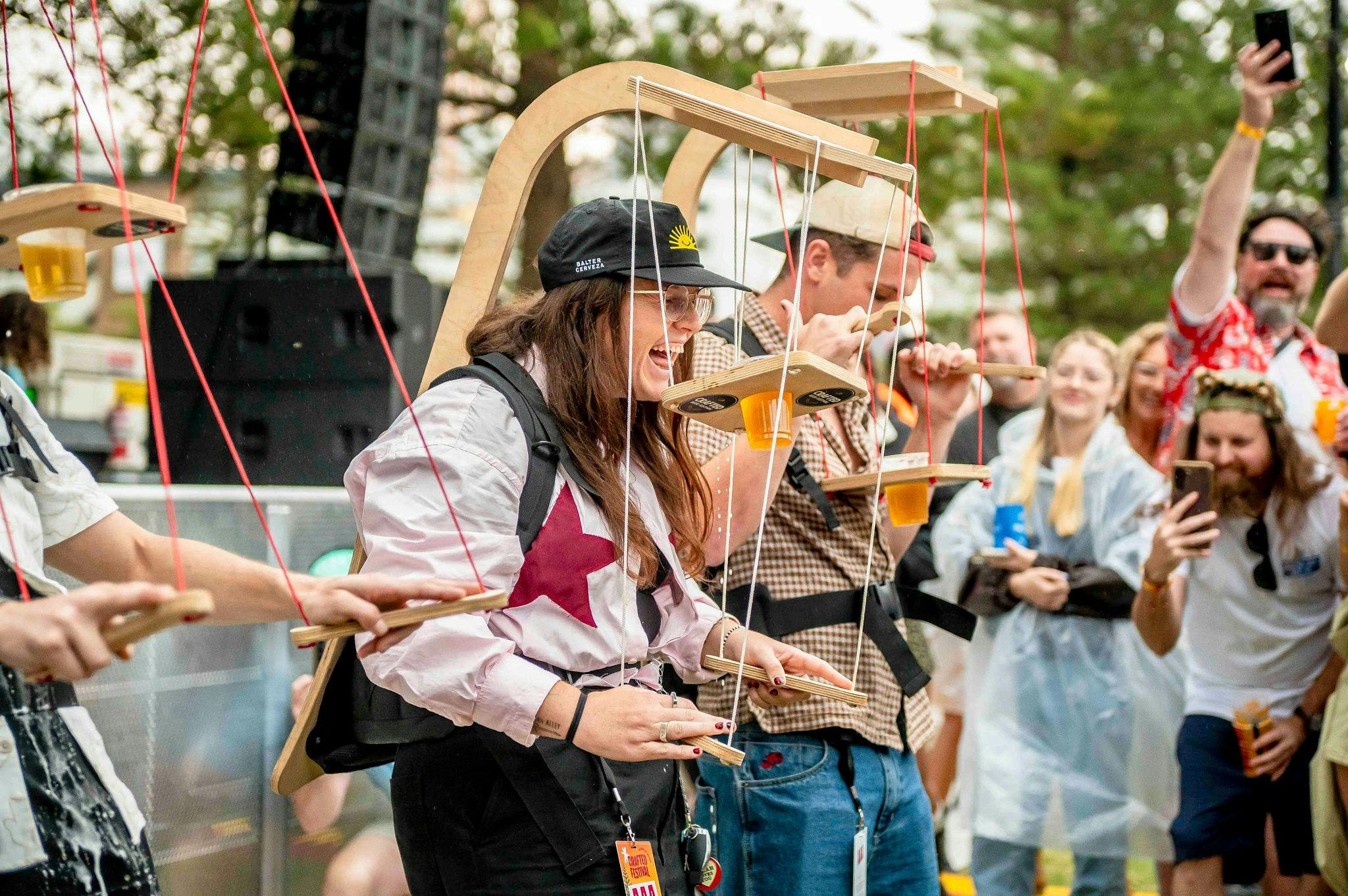3 people with beer puppeteer contraptions in a competition