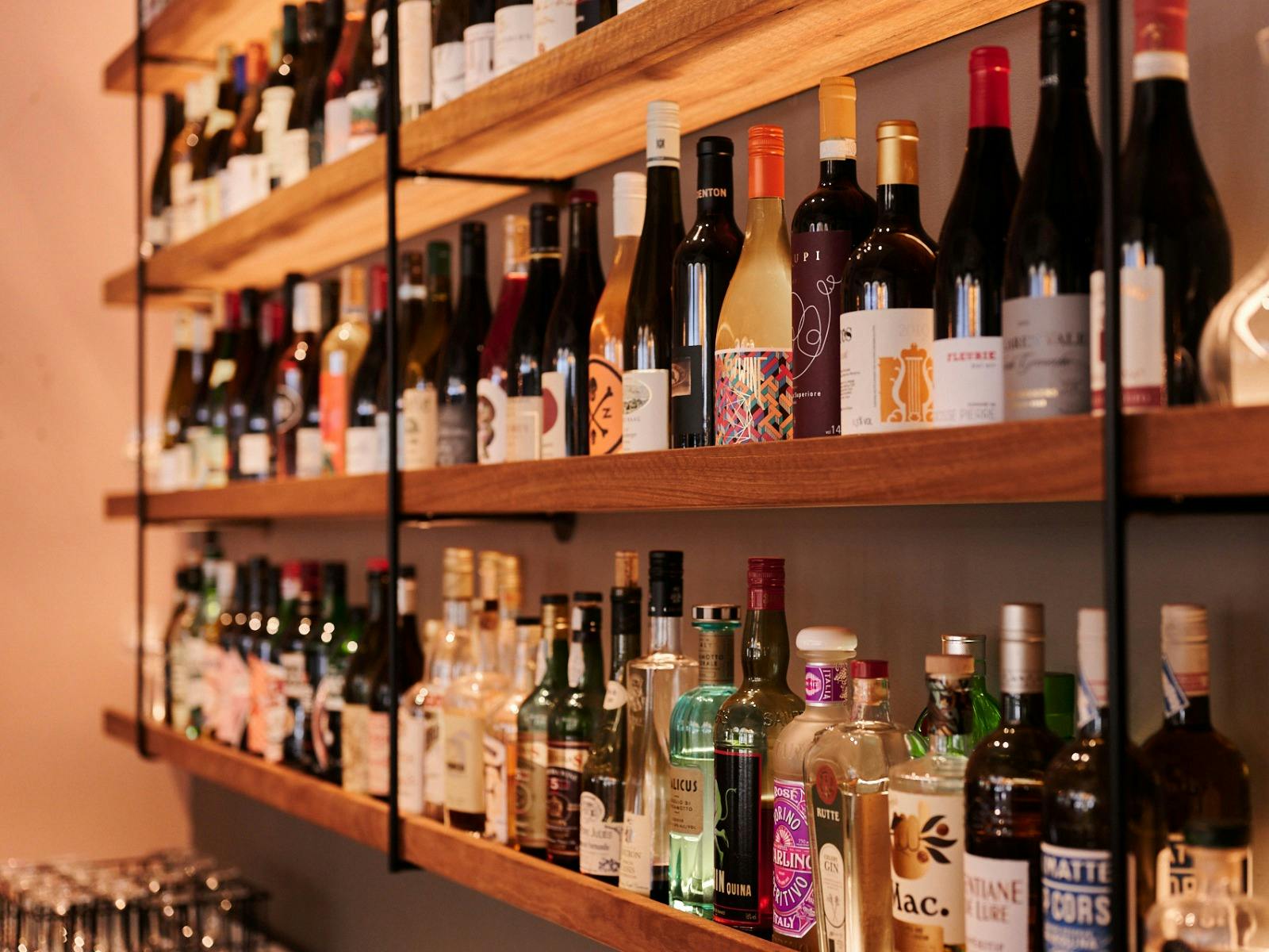 Wall shelf close up full of wine bottles