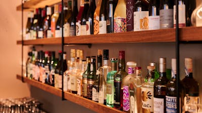 Wall shelf close up full of wine bottles